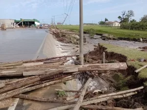 Residências alagadas, postes caídos e estrada danificada após ruptura do lago de areia